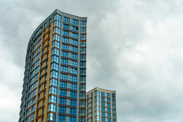 Fototapeta premium Modern skyscrapers in the new area. Tall buildings made of glass against the sky. Buying or renting luxury real estate.