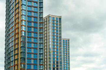Fototapeta premium Modern skyscrapers in the new area. Tall buildings made of glass against the sky. Buying or renting luxury real estate.