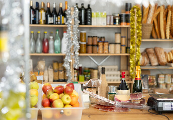 Different products on counter in grocery store decorated for new year..