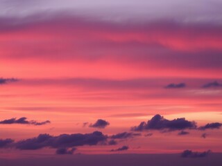 Fototapeta premium Vibrant hues of pink, orange, and purple streak across the sky at sunset, creating a mesmerizing and abstract display, atmospheric, clouds, horizon