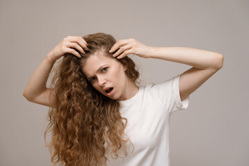 Fototapeta premium Woman scared, nervous, expression as she notices hair thinning and hair falling out. Hair loss problem and alopecia