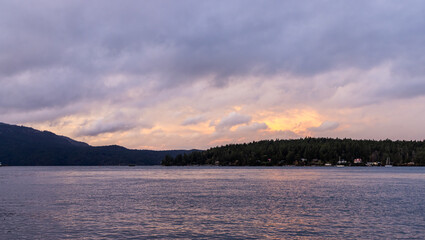 Serene Sunset View Over Coastal Waters with Tree-Lined Shoreline