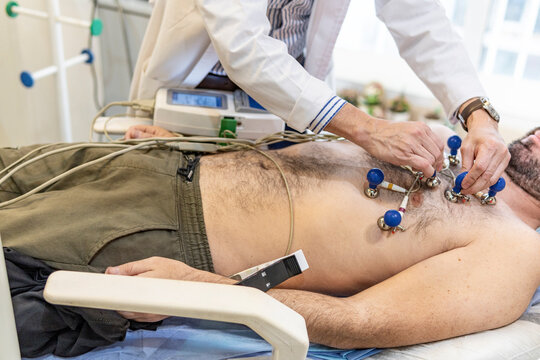 Patient undergoing cardiological examination. Doctor performing an electrocardiogram