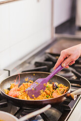 Chef cooking traditional ecuadorian seafood rice dish in madrid restaurant kitchen