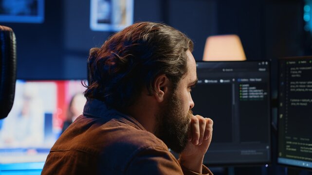 Developer overthinking solutions while doing programming during remote job shift in home office. IT admin working on computer in apartment late at night, thinking how to fix bugs, camera A close up