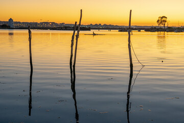 Obraz premium Tranquil water from a river at sunset with small recreational or fishing boats