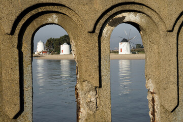 The 3 alburrica windmills with a wall in the foreground focused