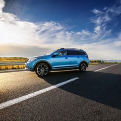 Fototapeta premium Sleek Metallic Blue SUV Racing on a Wide Highway
