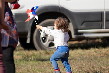 pequeño niño jugando con remolino de bandera chilena