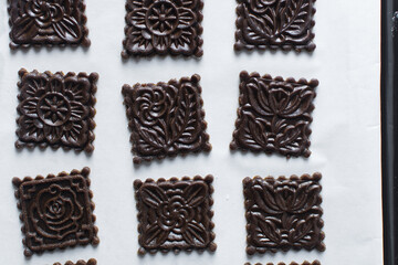 top view of stamped gingerbread cookie dough, Overhead view of cut out molasses cookie dough on a marble countertop, process of making christmas cookies