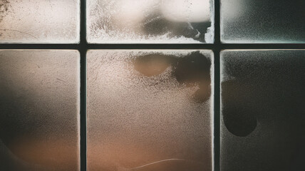 Foggy window panes with condensation create a dreamy atmosphere, evoking feelings of warmth and introspection.