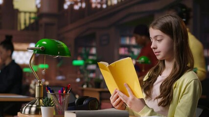 Teenager immersed in reading literary works from the school library database, focusing on her education and preparing for mandatory assignments or lectures. Diligent girl loves to read. Camera B.