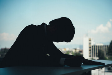 シルエットのビジネスマン（パワハラ・ストレス・悔しい・怒る・悲しい・辛い）
