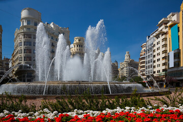 Impressive architecture and large round fountain on Town Hall Square in Valencia on sunny spring...