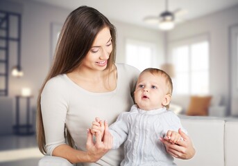 Loving mother carrying newborn baby at home.