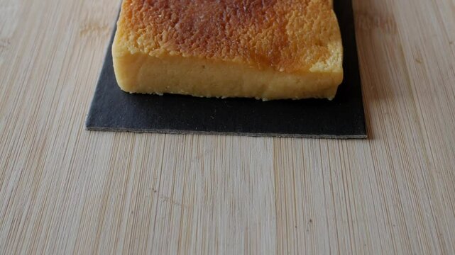 Turron Yema block on slate on wooden table, delightful dessert close-up