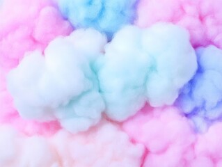 Fototapeta premium The image features fluffy cotton candy in pastel colors, primarily pink, blue, and lavender, creating a whimsical and soft visual effect.