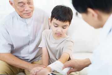 Obraz premium A doctor is treating a wound and providing first aid on a boy's arm.