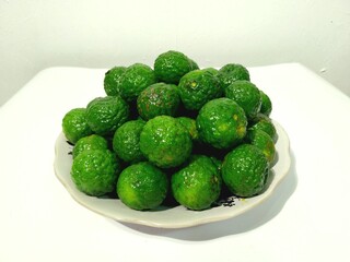 Fresh, vibrant green Kaffir Lime Fruits in a Dish