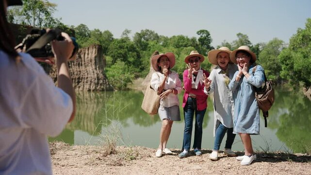 Elderly women are friends, inviting each other go see nature after retirement, using pension money, they were posing beautifully with still camera taking pictures them with beautiful natural scenery.