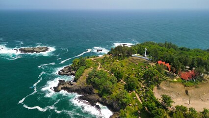 Aerial drone view of coastline with hills and trees, as well as view of coral cliffs and sea with waves from the ocean in Menganti Beach Kebumen Central Java Indonesia