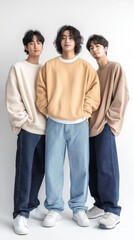 Fototapeta premium Three young male models posing in streetwear fashion on white background
