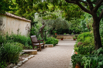 Obraz premium A serene garden with comfortable seating, lush greenery,and an inviting atmosphere for relaxation in the Mediterranean style of architecture.The scene includes cobblestone paths leading to small bench