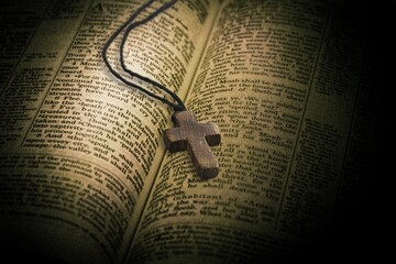 Wooden cross and opened page Holy Bible book