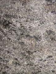 Close-up of granite stone floor with natural pattern texture in black and grey tones and shades. Durable textured surface for flooring in indoor and outdoor spaces background.