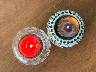 Two candles are lit on a wooden table