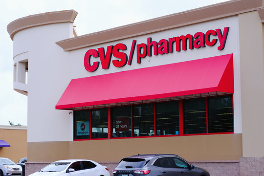 CVS Pharmacy store exterior with a bold red logo, large red awning and parked cars