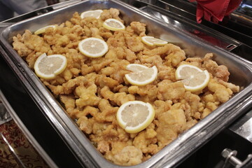friend calamary with lemon on stainless plate catering