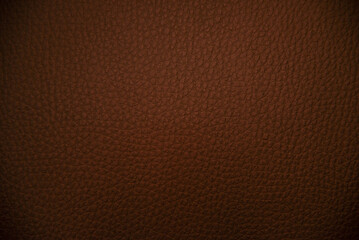 Fototapeta premium Close-up of rich brown leather texture with natural grain patterns and subtle highlights, perfect for backgrounds or designs.