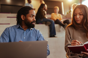 University students collaborating during lecture in modern auditorium