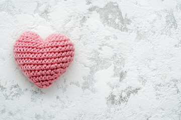 Obraz premium Soft pink crochet heart on textured surface, perfect for Valentine's Day decorations or gifts
