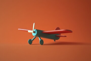 Teal and red toy airplane on orange background.