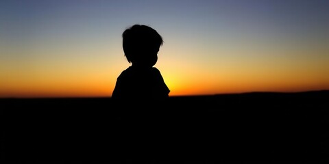Fototapeta premium Silhouette of a child gazing at the horizon as the sun sets in the distance, dusk, nostalgia, peaceful