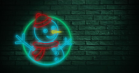 Snowman neon sign against copy space on green brick wall