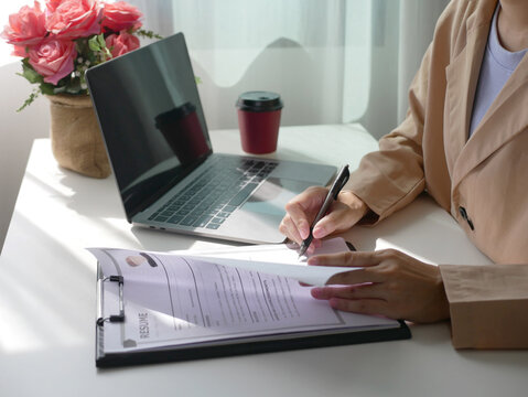 Businesswoman sits and evaluates resume and evaluates. Views resume of job applicant. Recruitment concept