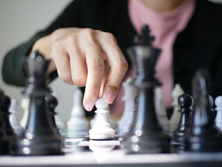 Asian businesswoman playing chess to plan business and market probability by using chess in work....