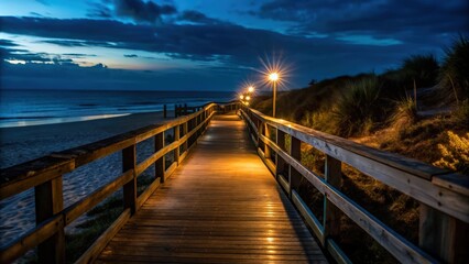 Obraz premium Illuminated Wooden Pathway Leading to the Ocean at Night