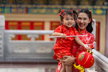 Young Mother and Daughter in Red Qipao Celebrating Chinese New Year