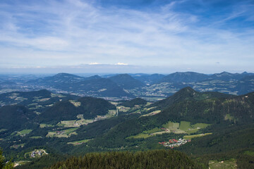 Fototapeta premium Looking down on hills and small villages below the Eagle's Nest on a spring day in Germany.