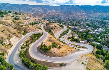 Fototapeta premium Aerial view of the winding mountain road , showcasing its unique topography and dramatic landscape