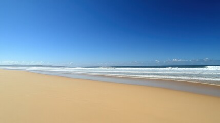 Tranquil Beach Scene with Clear Blue Sky and Gentle Ocean Waves
