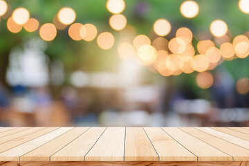 Empty wooden table  bokeh light background. Tables and chairs in the lobby of restaurant. Visitors to restaurant for dinner. Cozy bokeh lightening. Beautiful bright interior. Blurred bokeh basic backg