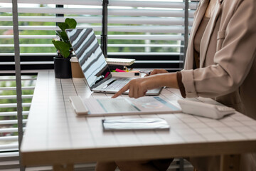 A woman is pointing at a graph on a piece of paper. The graph shows a comparison between two sets...