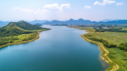Aerial view of a serene lake surrounded by lush greenery and distant mountain, nature, background.