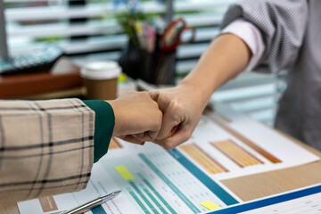 Two people shaking hands in front of a table with papers and a calculator. Scene is professional and friendly