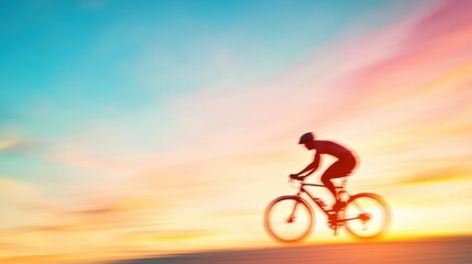 Fototapeta premium Silhouette of a Cyclist in Motion Against a Vibrant Sunset Background with Colorful Skies and Dreamy Atmosphere